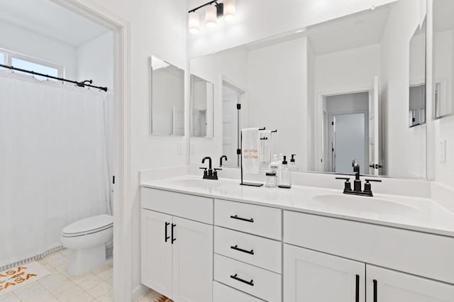 bathroom featuring toilet, vanity, and tile patterned flooring