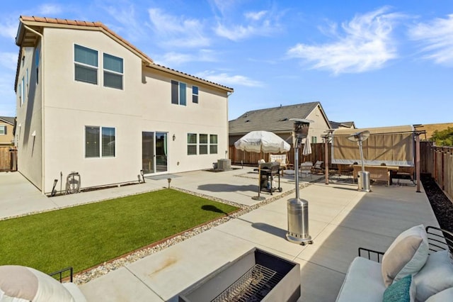 rear view of property with cooling unit, a yard, and a patio