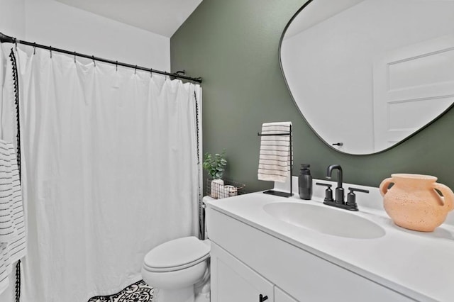 bathroom featuring toilet, vanity, and a shower with shower curtain