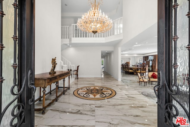 entrance foyer featuring a towering ceiling and a notable chandelier