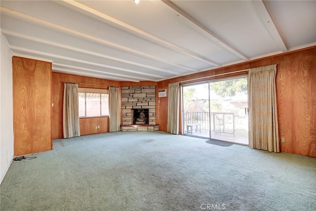 unfurnished living room featuring carpet floors, wood walls, beamed ceiling, and a fireplace