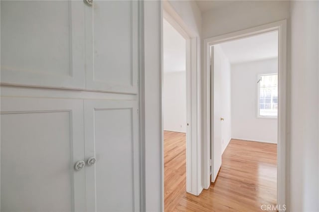 hallway with light hardwood / wood-style flooring