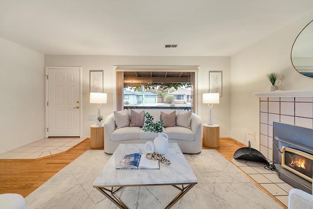 living room with light hardwood / wood-style floors and a wood stove