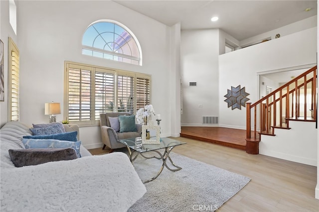 living room featuring wood-type flooring and a high ceiling