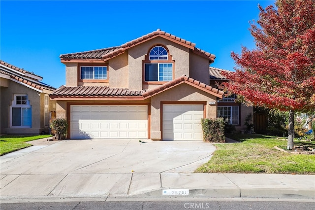 mediterranean / spanish-style home with a garage and a front yard