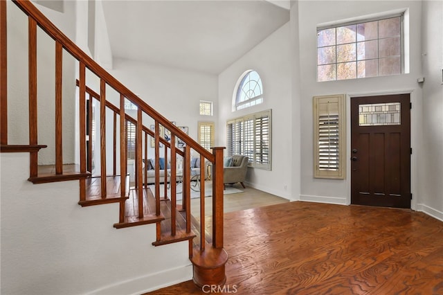 foyer with a wealth of natural light, a high ceiling, and hardwood / wood-style flooring