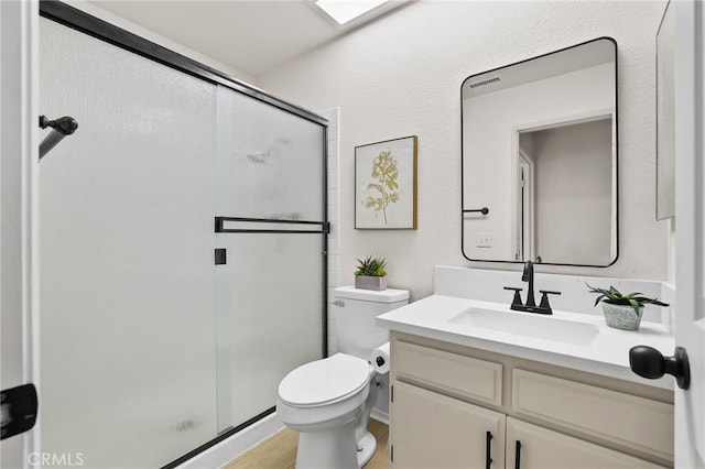 bathroom featuring toilet, vanity, wood-type flooring, and walk in shower