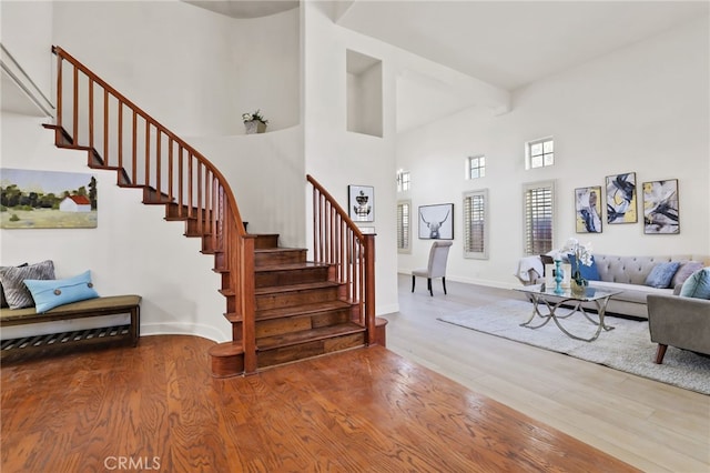 interior space with hardwood / wood-style flooring and a towering ceiling