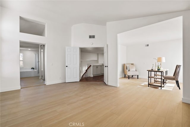 interior space featuring a towering ceiling and light hardwood / wood-style floors