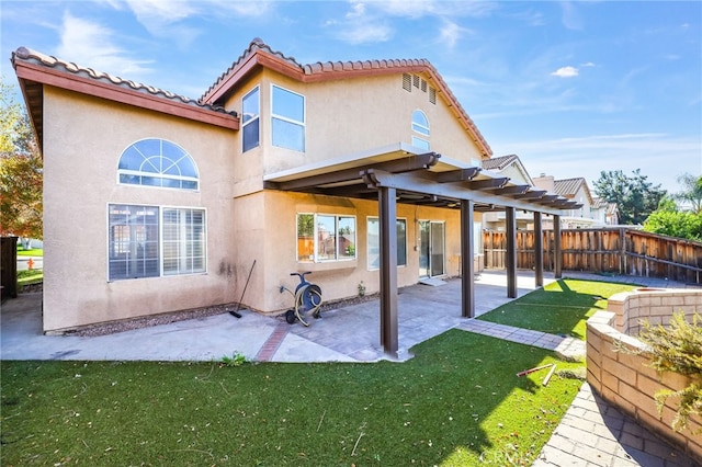 back of house featuring a lawn and a patio area