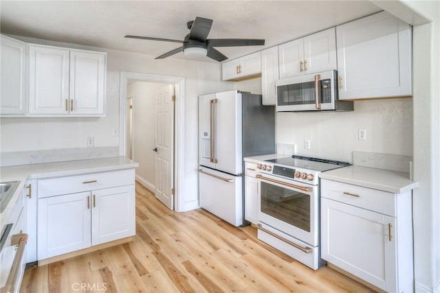 kitchen featuring white cabinets, ceiling fan, light wood-type flooring, and white appliances