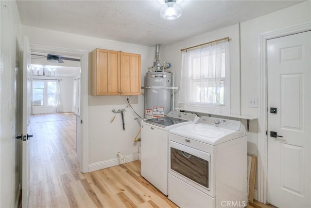 clothes washing area featuring cabinets, light wood-type flooring, a textured ceiling, water heater, and washer and dryer