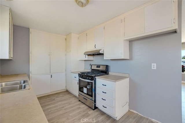 kitchen featuring gas range, white cabinetry, and light hardwood / wood-style flooring