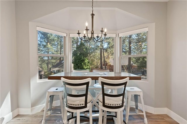 dining space with light hardwood / wood-style floors and a chandelier