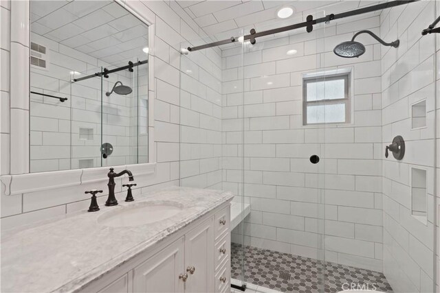 bathroom featuring vanity and a shower with door