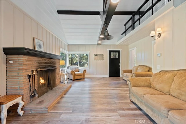 living room with vaulted ceiling with beams and hardwood / wood-style floors