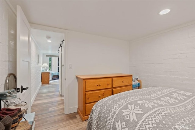 bedroom featuring crown molding and light hardwood / wood-style floors