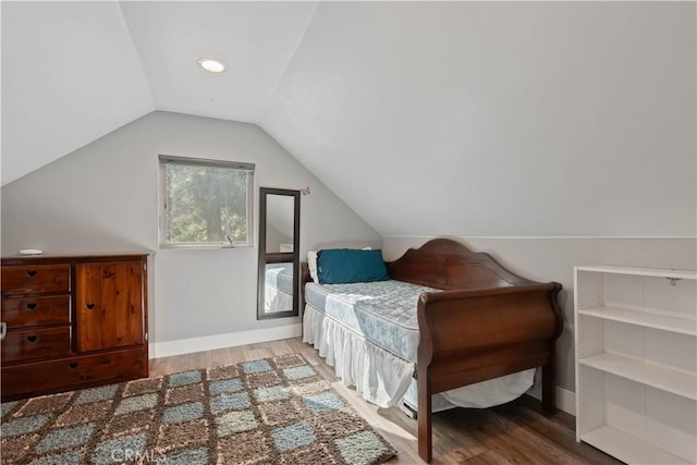 bedroom with vaulted ceiling and hardwood / wood-style flooring