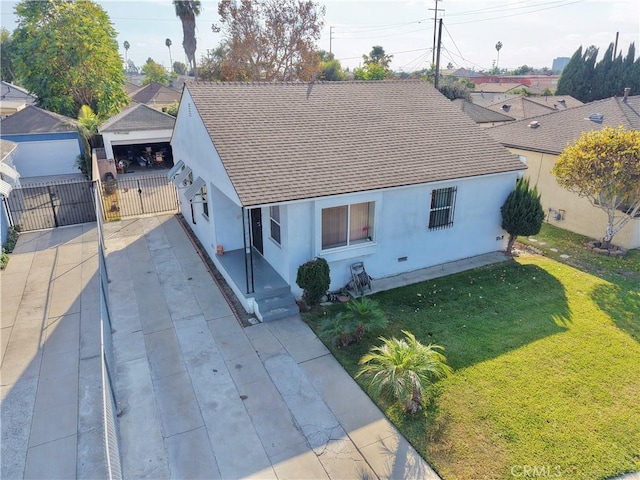 view of front of house featuring a garage, a front lawn, and an outdoor structure