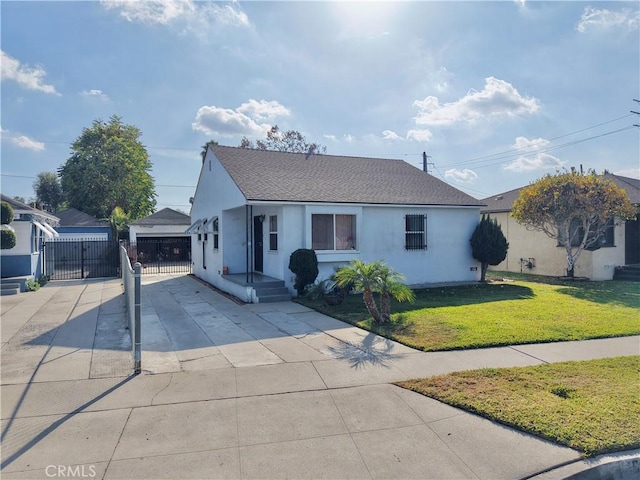 view of front of home with a front yard, a garage, and an outdoor structure