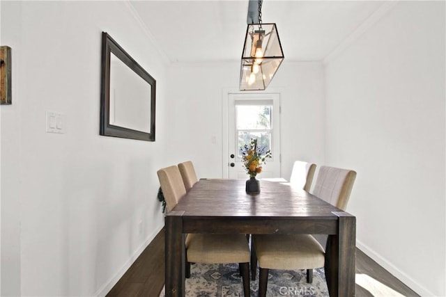 dining area featuring hardwood / wood-style floors and crown molding