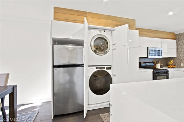 laundry area with dark hardwood / wood-style flooring and stacked washer and dryer