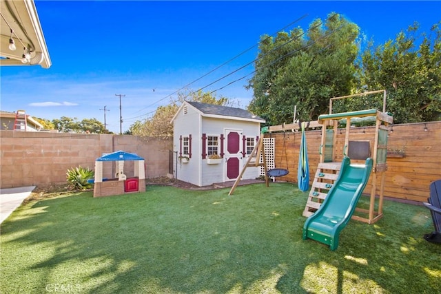 view of jungle gym with a yard and a storage shed