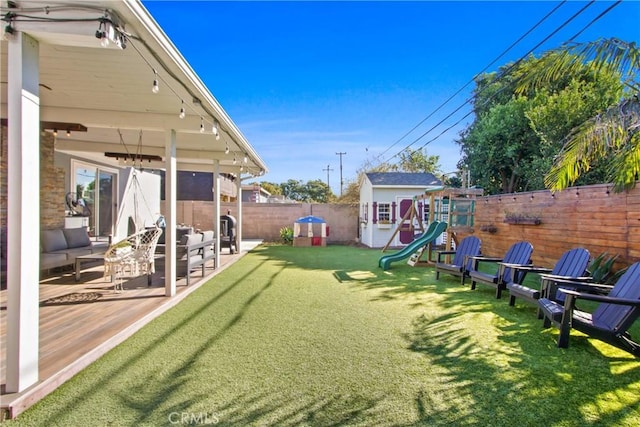 view of yard with a patio area, a playground, and a storage unit