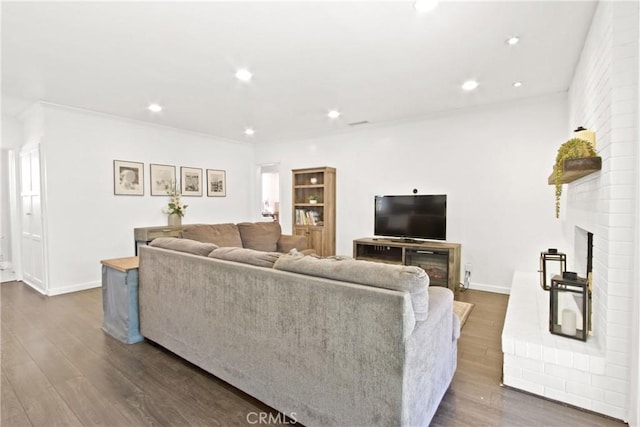 living room with dark hardwood / wood-style flooring and a fireplace