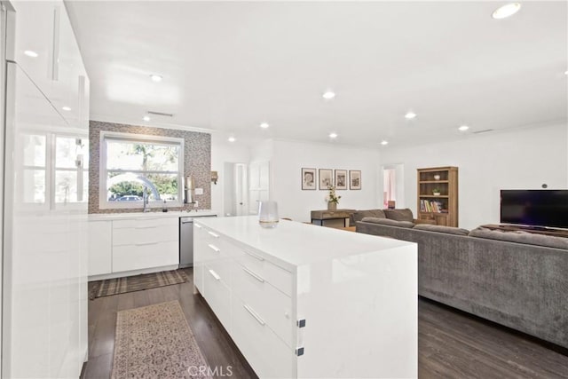 kitchen featuring white cabinetry, a center island, dark wood-type flooring, and stainless steel dishwasher