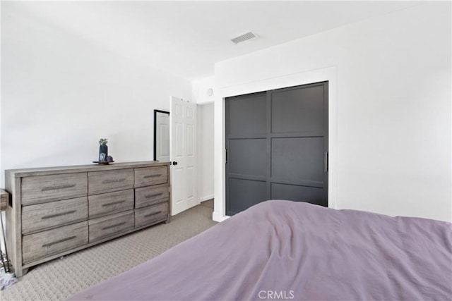 bedroom featuring light colored carpet and a closet