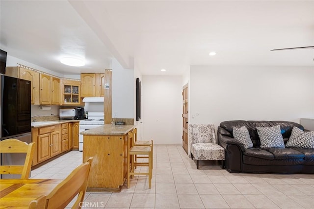 kitchen with a kitchen breakfast bar, black fridge, sink, white electric stove, and light tile patterned flooring