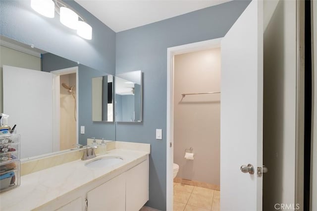 bathroom with toilet, vanity, and tile patterned floors