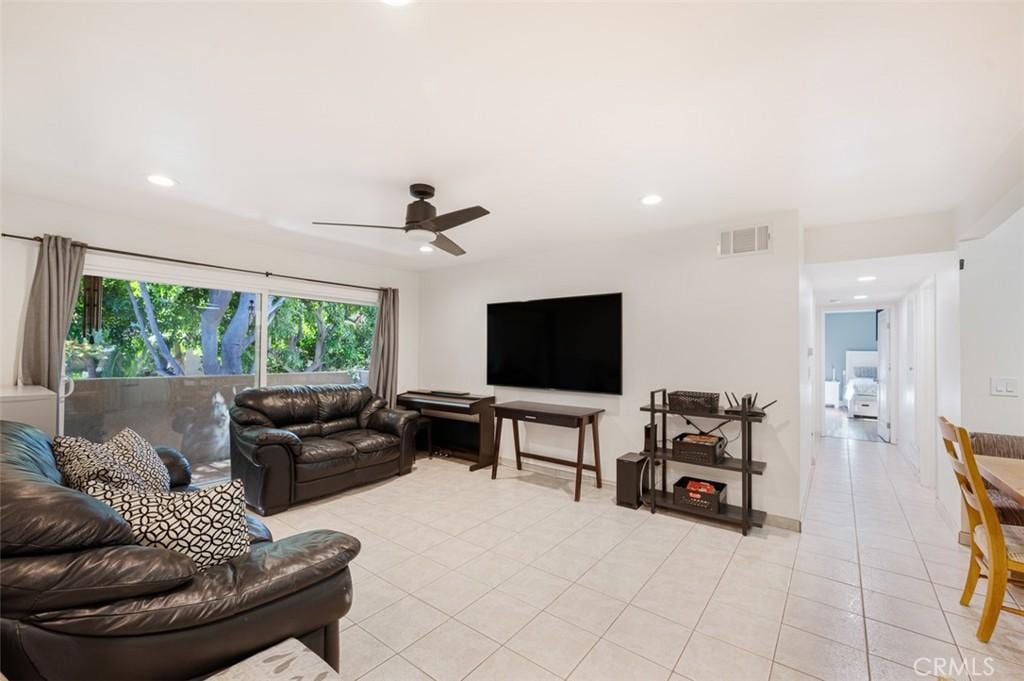 tiled living room with ceiling fan