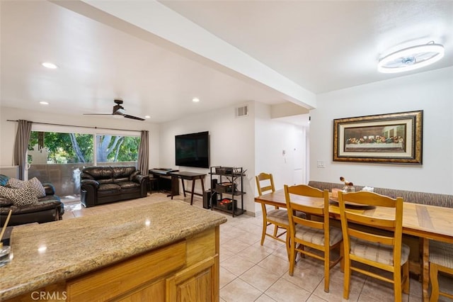 kitchen with light stone counters, ceiling fan, and light tile patterned floors