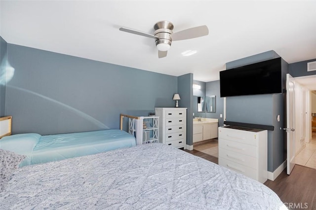 bedroom featuring ensuite bath, ceiling fan, and hardwood / wood-style flooring