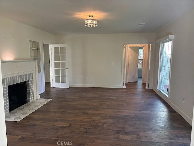 unfurnished living room featuring a fireplace and dark hardwood / wood-style flooring