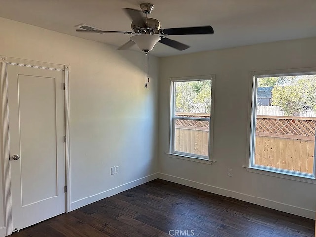 unfurnished room with ceiling fan and dark hardwood / wood-style flooring