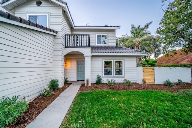 property entrance featuring a lawn and a balcony