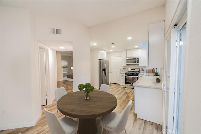 dining space featuring sink and light wood-type flooring