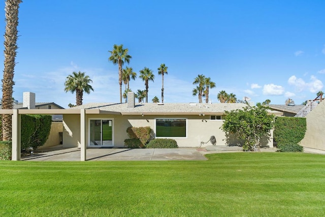 rear view of house with a lawn and a patio