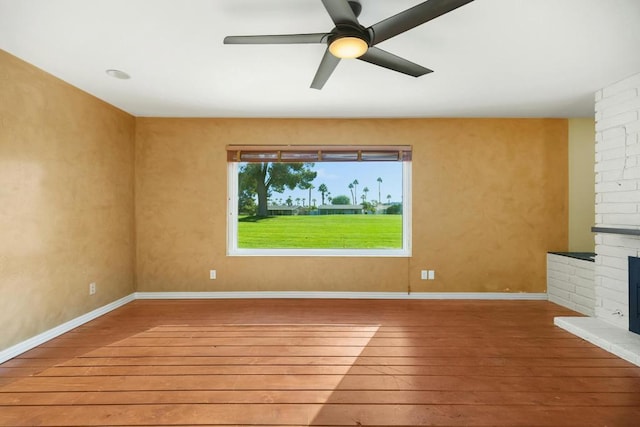 unfurnished living room with ceiling fan, a fireplace, and hardwood / wood-style floors