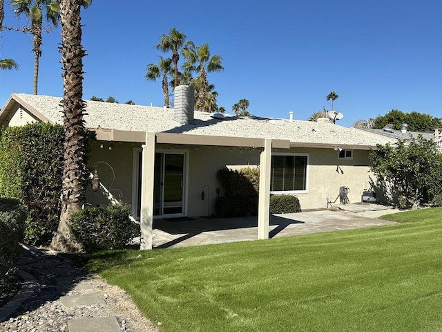 back of house featuring a patio and a lawn