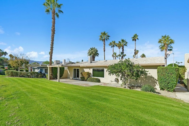 rear view of house with a patio and a lawn