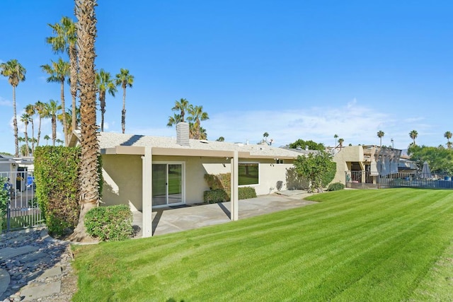 rear view of property with a yard and a patio area