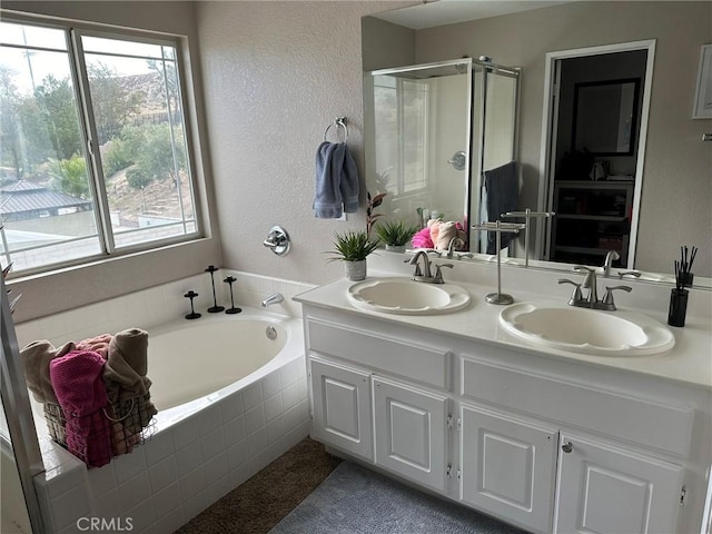 bathroom featuring vanity, separate shower and tub, and a healthy amount of sunlight