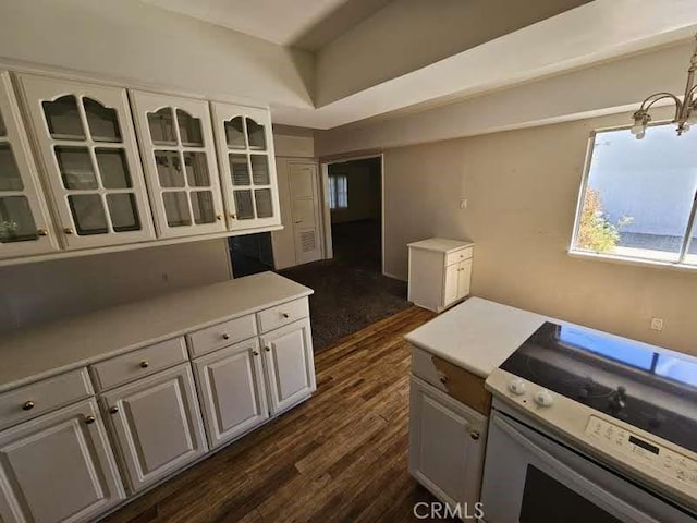 kitchen featuring pendant lighting, an inviting chandelier, white cabinets, electric range, and dark hardwood / wood-style flooring