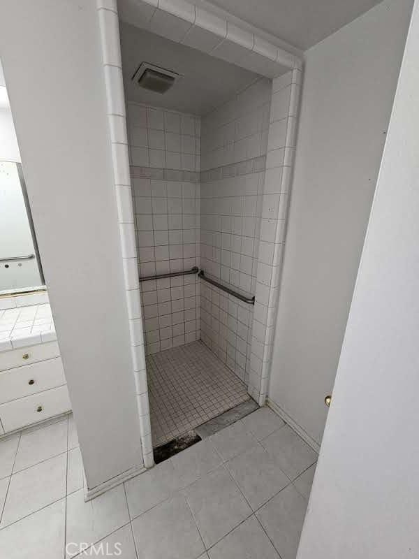 bathroom featuring tile patterned floors and tiled shower