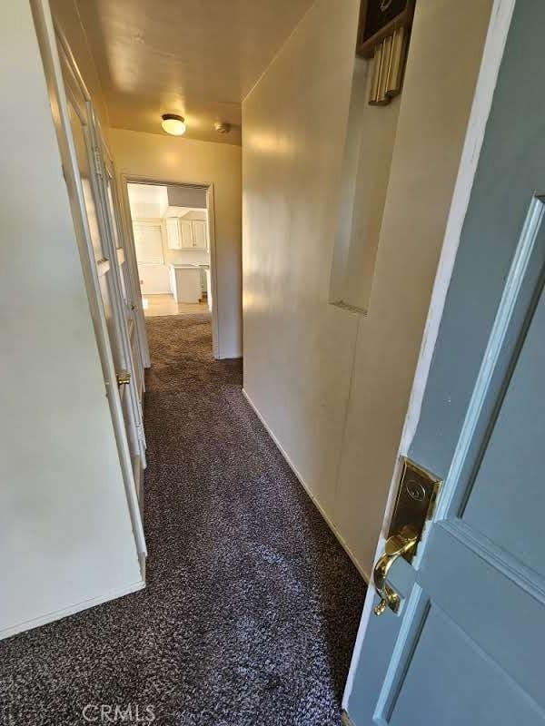 hallway featuring dark carpet