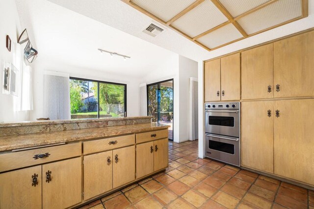 kitchen featuring light brown cabinets and double oven